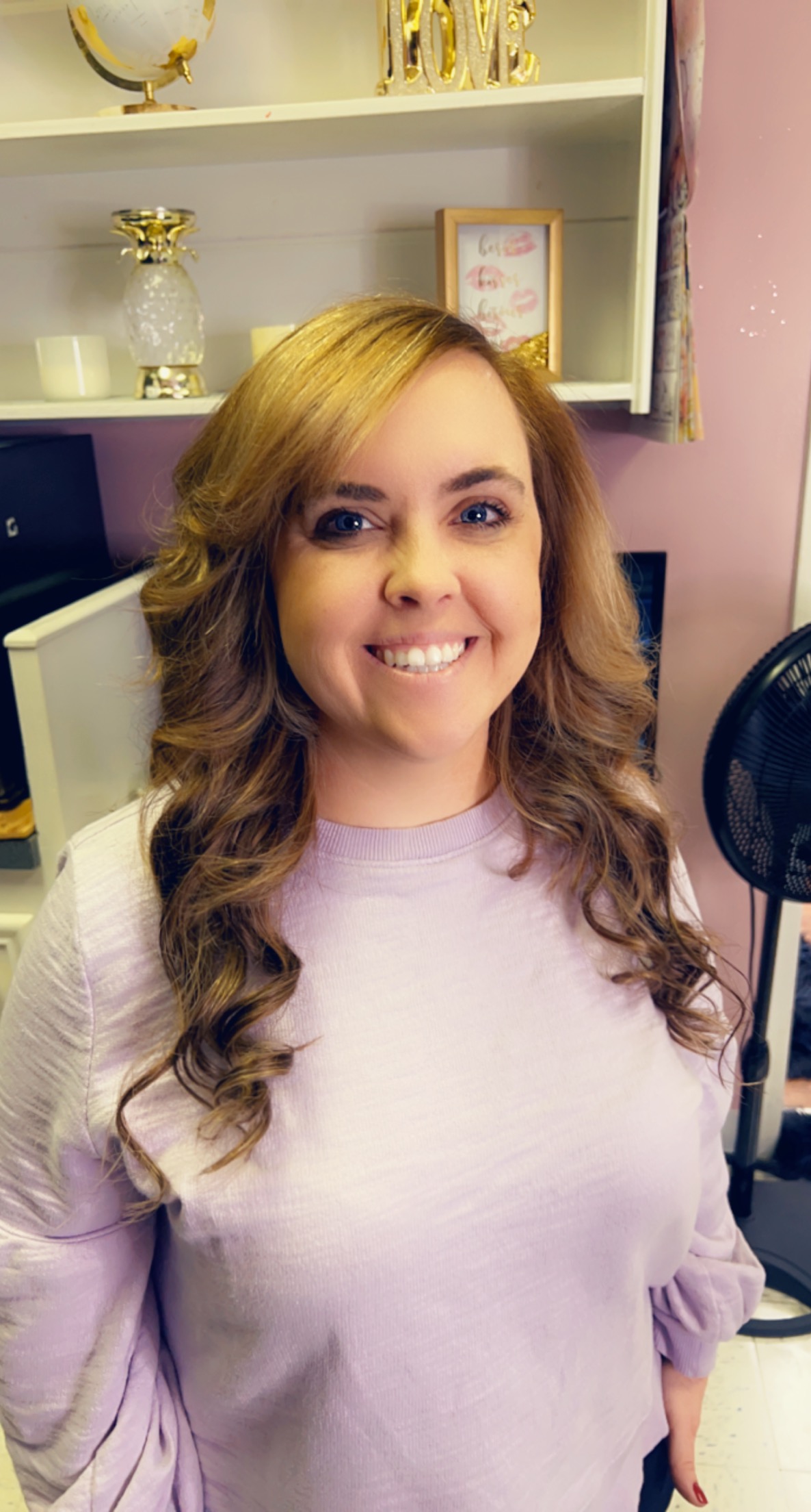 Smiling client with long, soft curls in the studio